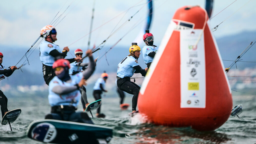 Der deutsche Kitesurfer KJannis Maus im Feld der Formula Kite-WM, alle Fahrer fahren auf eine Bahnmarke zu.