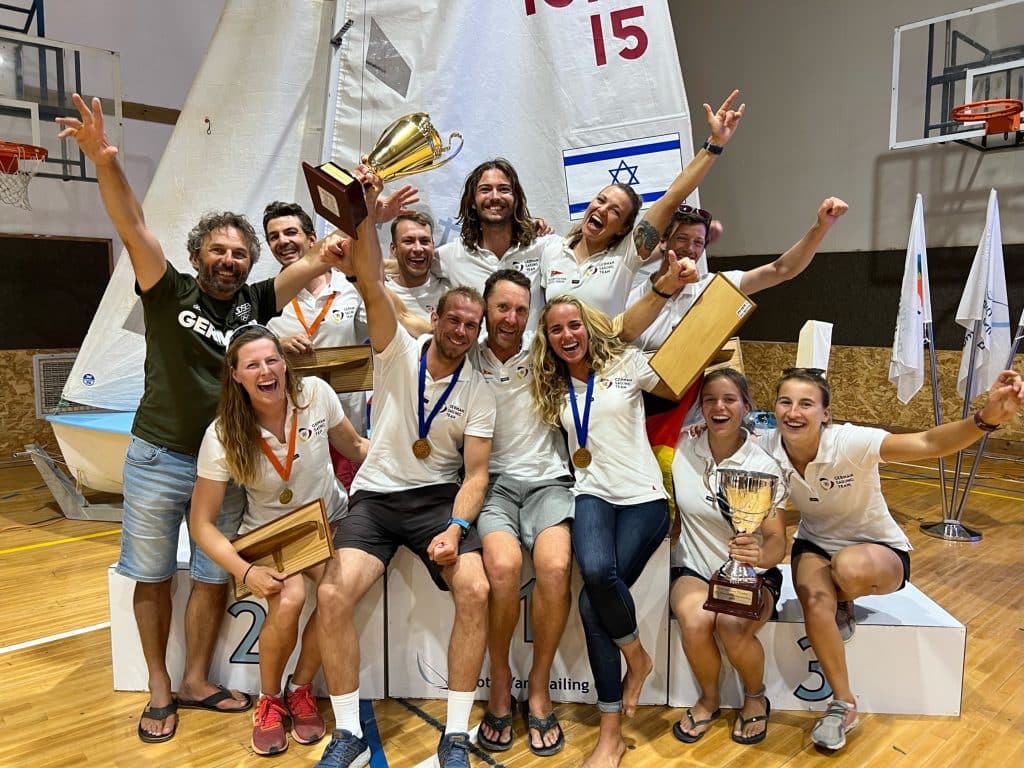 Happy Coach: Steve Lovegrove (in der Mitte zwischen Philipp Autenrieth und Luise Wanser) jubelt über 470er-WM-Gold für Deutschland. Ganz links: Trainerkollege Marek Chocian. Beide tauschen sich eng aus. Foto: privat 