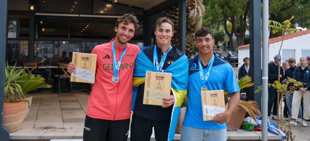 Drei Männer stehen vor einem Siegerpodest, sie haben Urkunden und Medaillen, der ganz linke trägt eine Germany Sweatjacke.