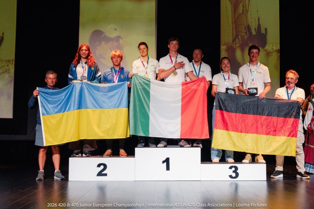 Sechs Personen mit den Flaggen von Italien, der Ukraine und Deutschland stehen auf einem Podest.