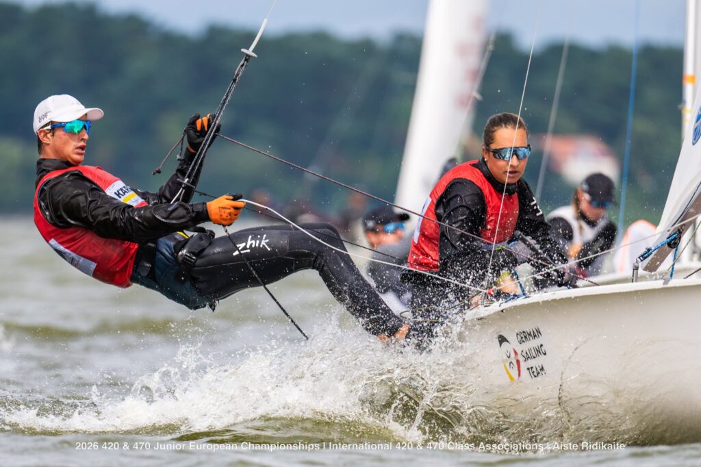 Eine Frau und ein Mann mit roten Schwimmwesten auf einer 470er Jolle