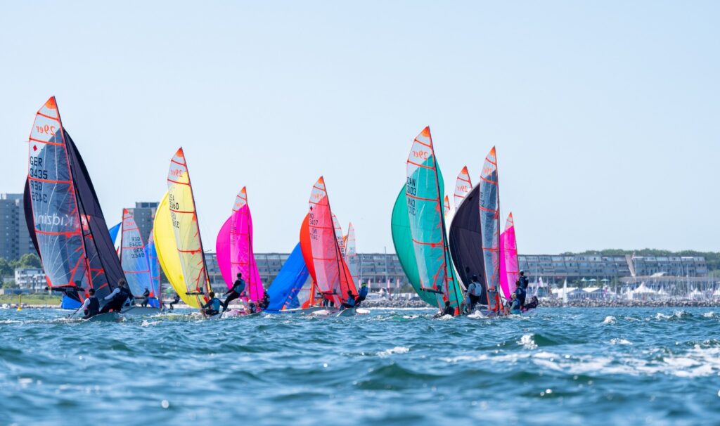 Seglerinnen und Segler der vorolympischen Skiff-Klasse 29er segeln unter Gennaker auf blauem Ostseewasser.